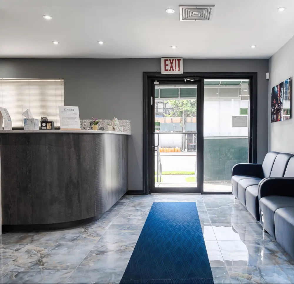 Reception area with check-in desk and waiting seating at Queensboro Oral Surgery